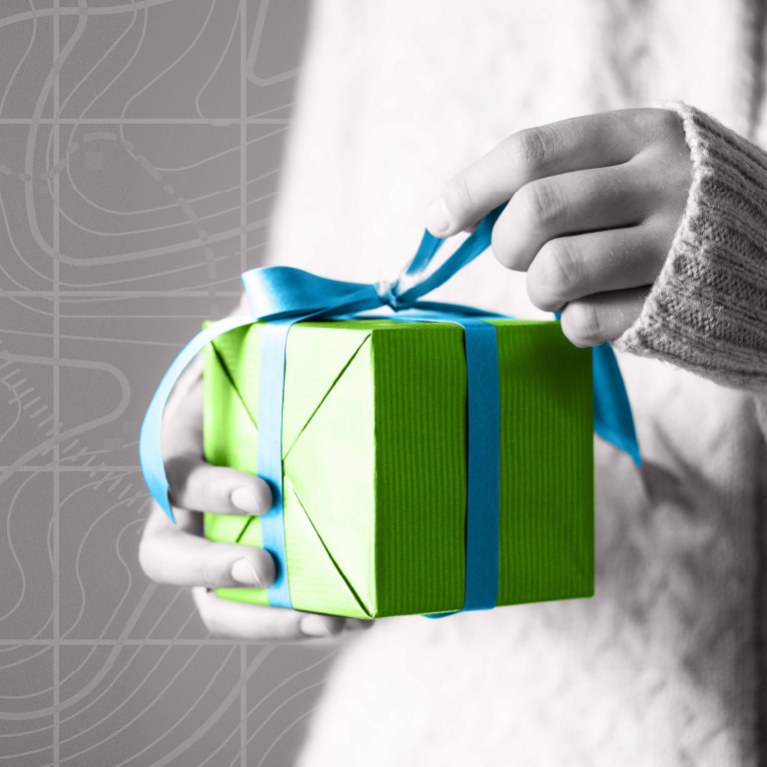 hand opening a blue box gift with a green ribbon