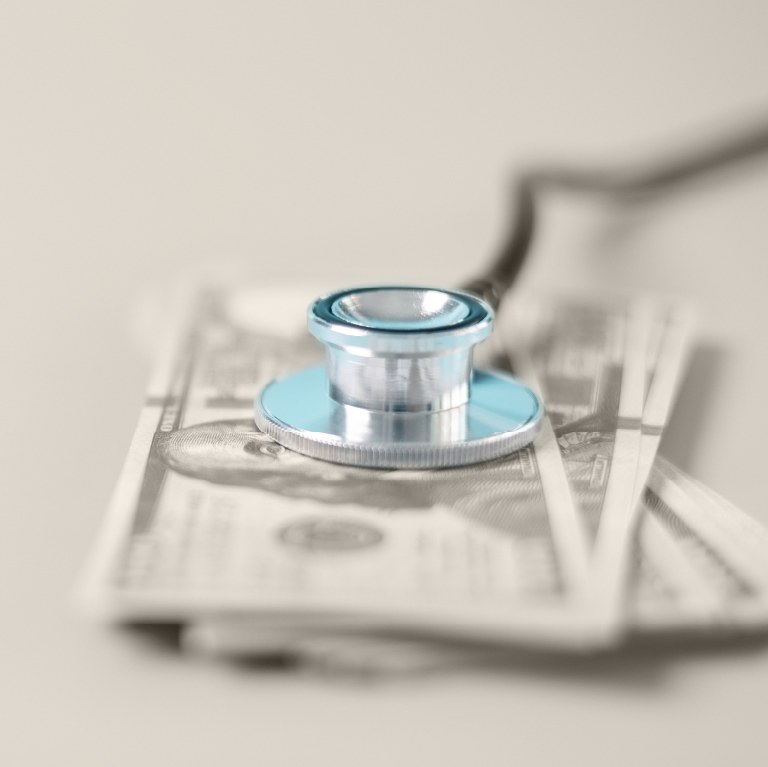 A blue STEthoscope over cash